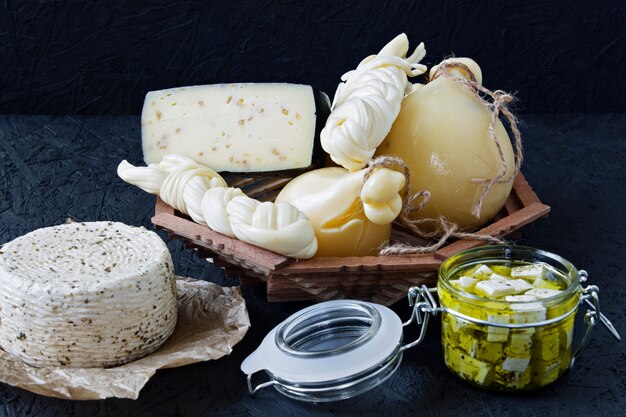 Tipos diferentes de queijo em um fundo preto. prato de queijos