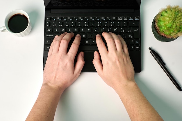 Tipos de hombre en una computadora portátil sobre un fondo blanco. Concepto de negocio