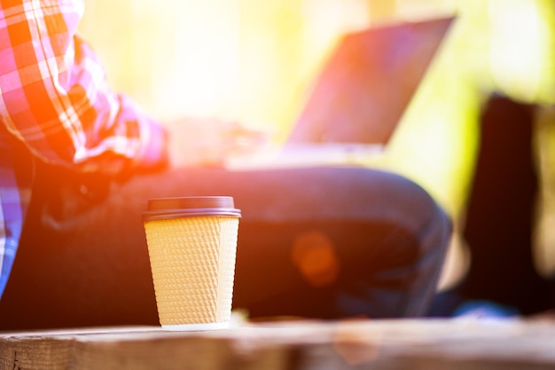 Tippen auf einem Laptop mit einer Tasse Kaffee am Morgen