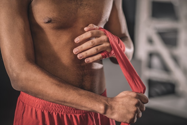 Tippende Hände. Kickboxer tippt vor dem Training einen Verband auf seine Hand