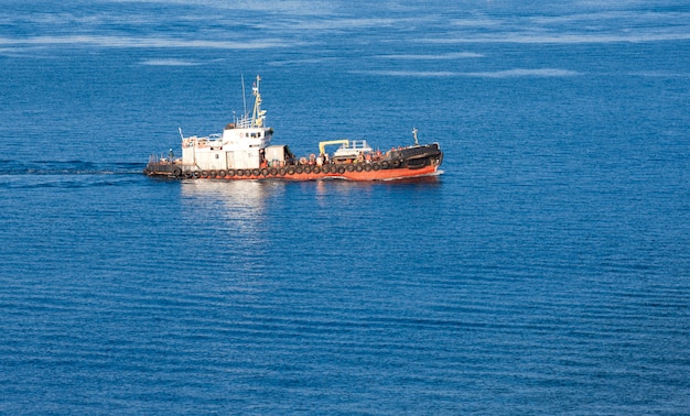 Tira del barco en un soleado día de otoño en el mar azul