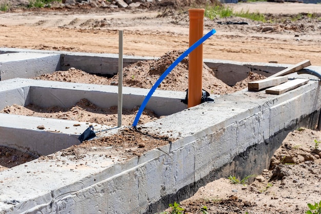 Tira de cimientos de un nuevo edificio Los cimientos para la construcción de las paredes de la casa Realización de comunicaciones al edificio debajo de los cimientos