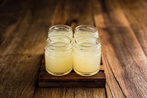 Tiradores alcohólicos de color amarillo, o tragos en la mesa de madera