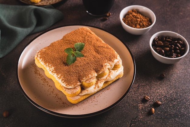 Tiramisu bolo feito de biscoitos creme delicado e café em um prato na mesa