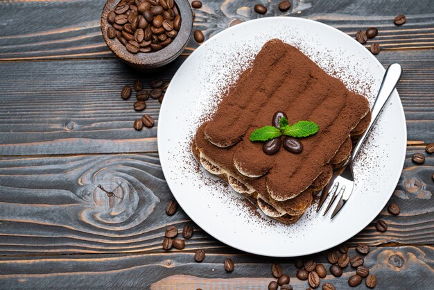 Tiramisú clásico postre en plato de cerámica sobre fondo de madera