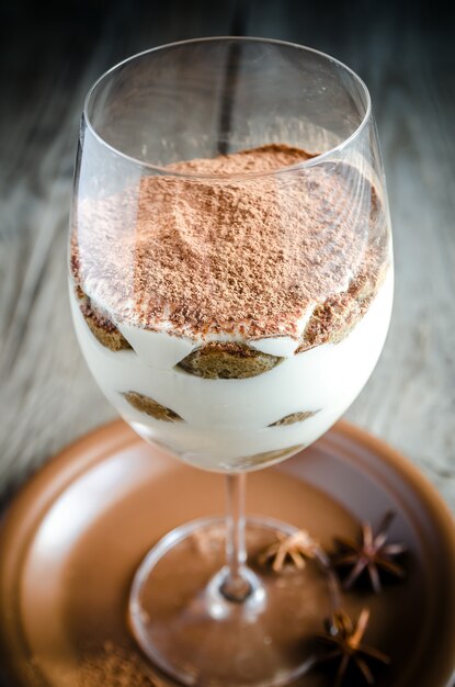 Foto tiramisú en el cristal en el fondo de madera