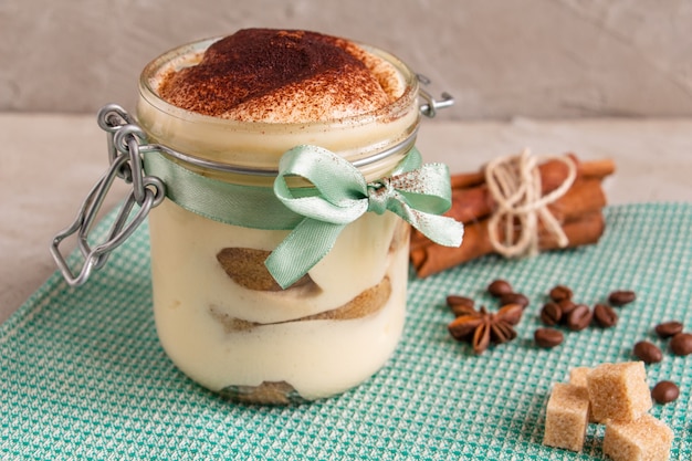 tiramisú en un frasco con una cinta azul en una hermosa servilleta