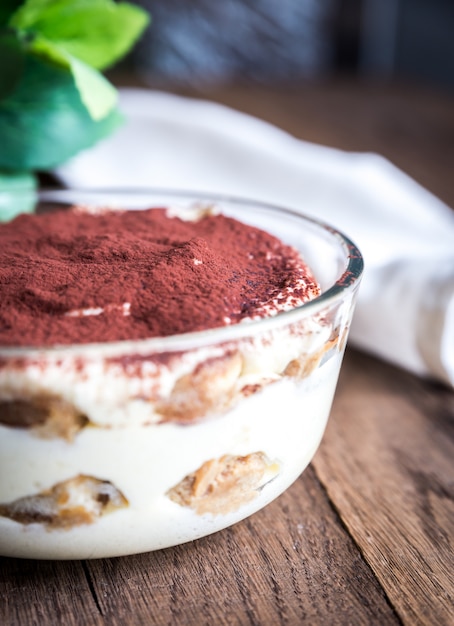 Tiramisu na tigela de vidro em madeira