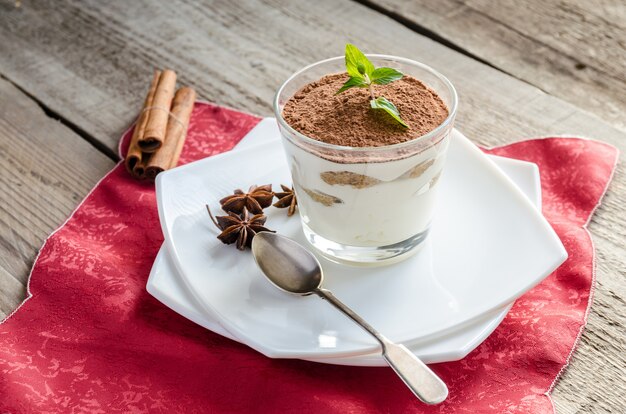 Tiramisu no copo na mesa de madeira