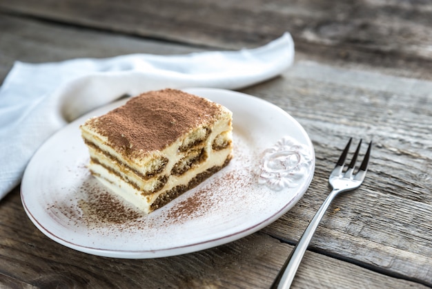 Tiramisu no prato na mesa de madeira