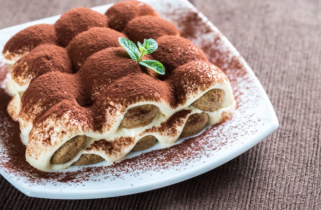 Tiramisu no prato na mesa de madeira