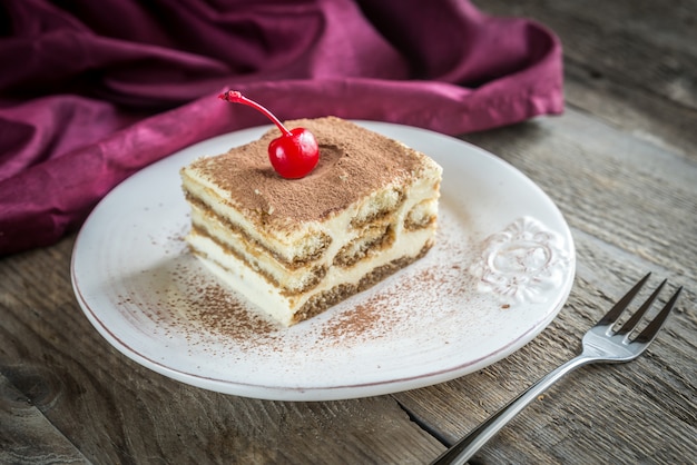 Tiramisú en el plato sobre la superficie de madera