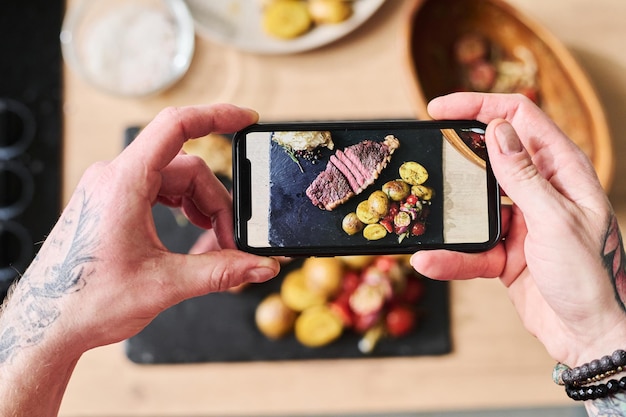 Tirando foto de bife com acompanhamento