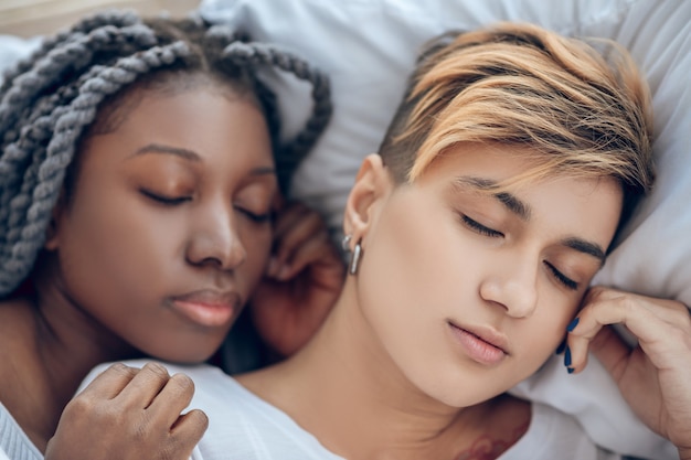 Tirando uma soneca. Duas meninas deitadas na cama dormindo