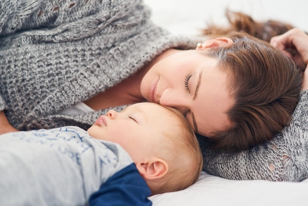 Tirando uma soneca rápida Foto recortada de uma mãe e seu filho dormindo juntos em casa