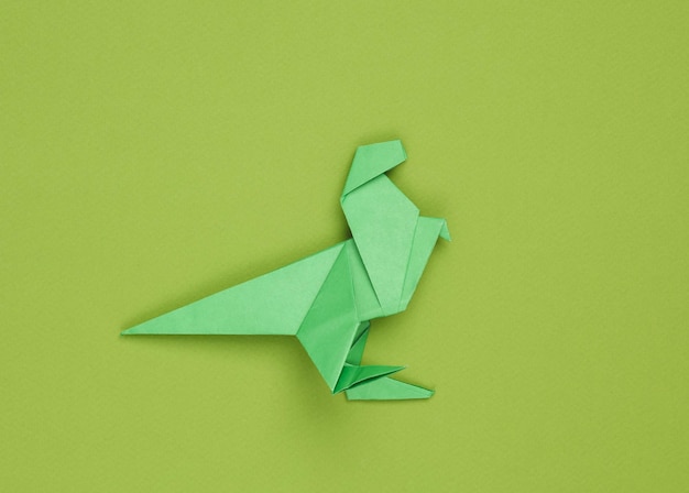 El tiranosaurio rex de papel origami sobre un fondo verde