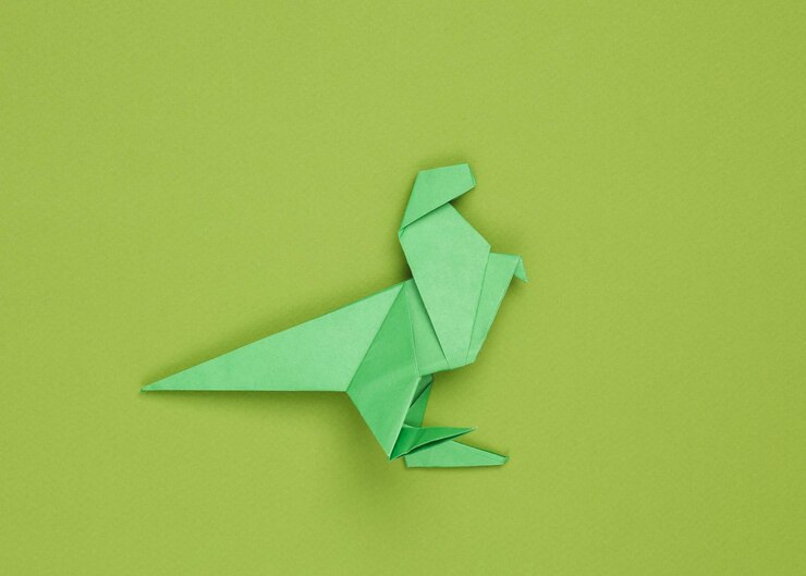 Foto el tiranosaurio rex de papel origami sobre un fondo verde
