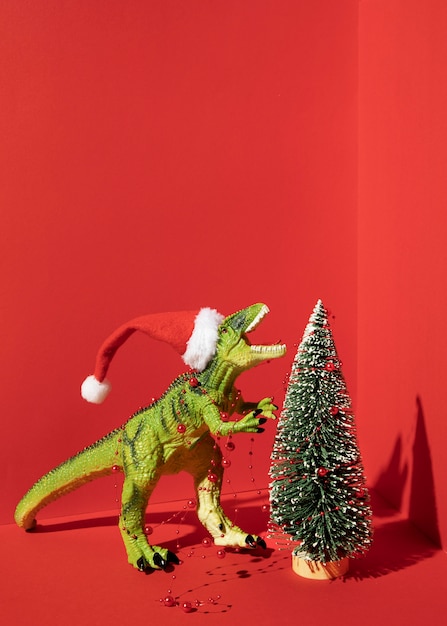 Tiranossauro rex de brinquedo com árvore de natal