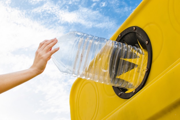 Tirar una botella al contenedor de reciclaje