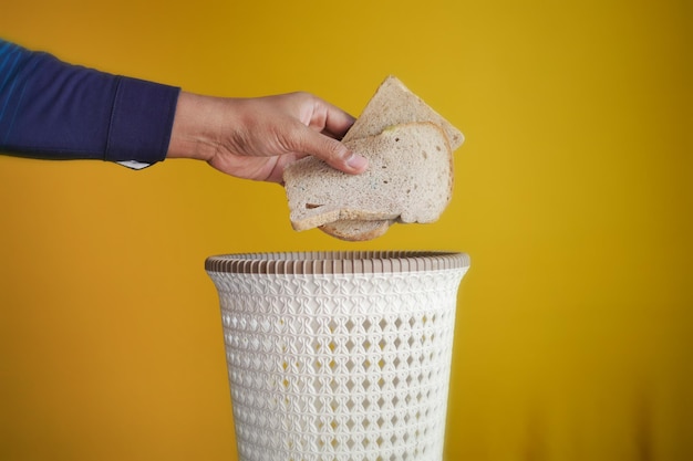 Tirar panes en un cubo de basura