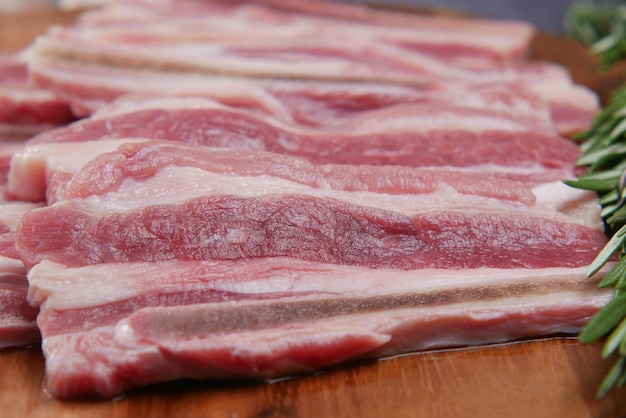 Tiras de bacon com comida crua na tábua de cortar