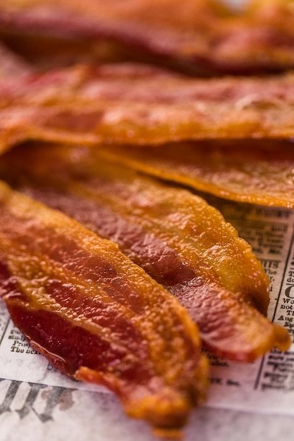 Tiras de bacon cozidas em um jornal.