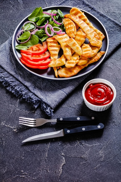 Tiras de pollo a la parrilla en un plato con verduras