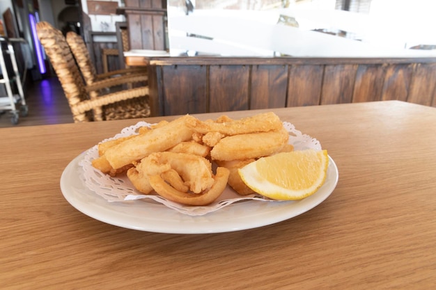 Tiras de sepia fritas, llamadas Chocos Fritos en español. Se sirve en un plato blanco.