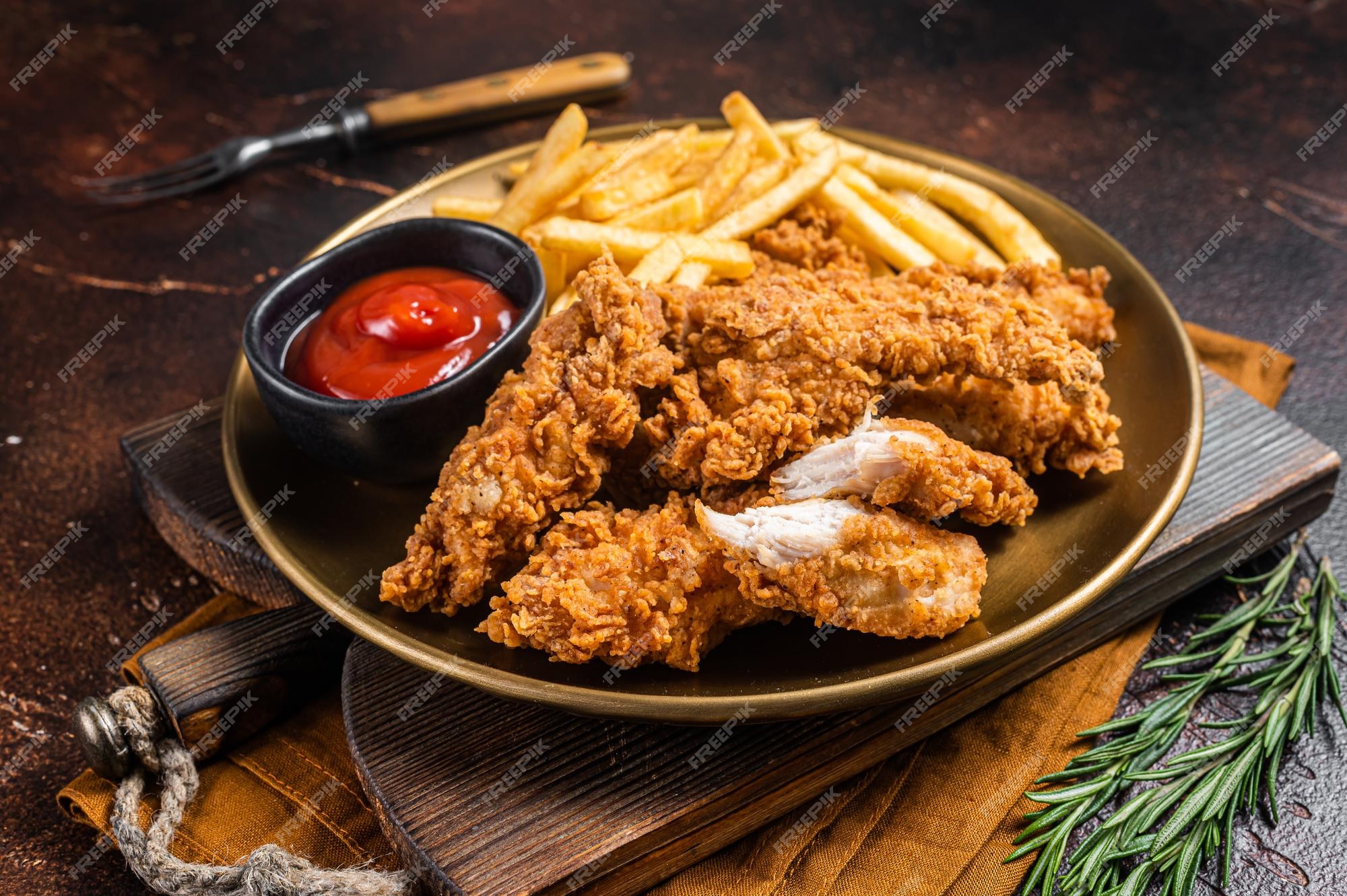 Tiras tiernas de pollo empanizado frito con papas fritas y salsa de tomate en un plato fondo oscuro vista superior | Foto Premium Tiras tiernas de pollo empanizado frito con papas fritas y salsa de tomate en un plato fondo oscuro vista superior | Foto Premium