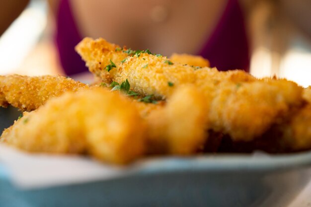 Tiras de tilapia brasileña frita fresca con lima y salsa tártara conocida como isca de peixe Aperitivo brasileño tradicional Enfoque selectivo