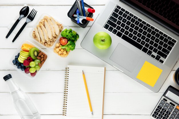 Tire alimentos ricos em nutrientes com o laptop e o equipamento em cima da mesa preparada para trabalhar em casa