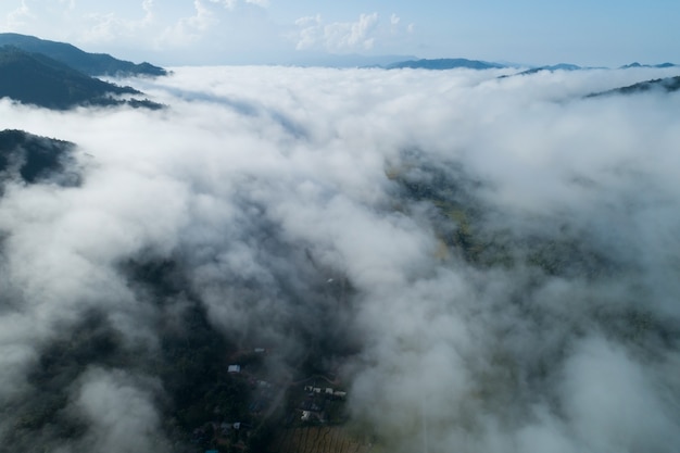 Tiro de abejón de vista aérea de ondas de niebla que fluyen en la selva tropical de montaña, imagen de vista de pájaro sobre las nubes Fondo de naturaleza increíble con nubes y picos de montaña en Nan Tailandia.