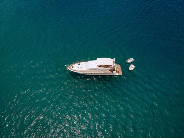 Tiro del abejón del yate blanco hermoso en el mar azul cálido; concepto de riqueza.