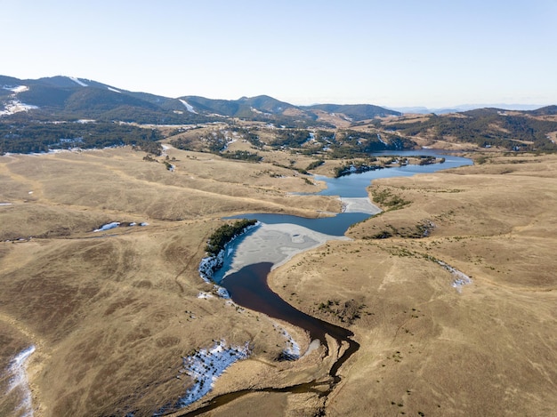 Tiro aéreo do rio entre as montanhas do deserto.