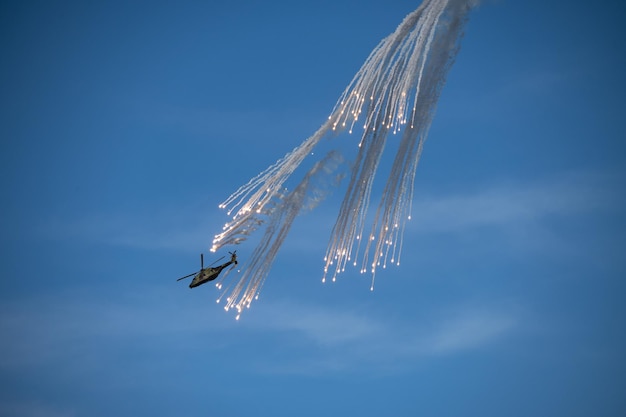 Tiro de ángulo bajo de un avión con fuegos artificiales en el cielo azul claro