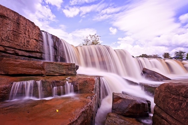 Tiro de cascada de ángulo bajo con cielo azul