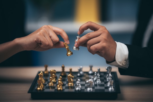 Tiro de cerca ajedrez dorado para derrotar al ajedrez asesino del rey de plata en el tablero de ajedrez blanco y negro para el concepto de ganador y perdedor de la competencia de desafío comercial