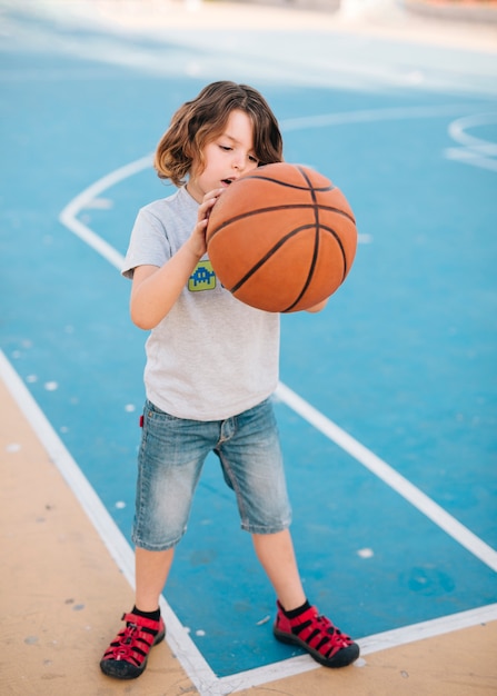 Tiro completo de criança jogando basquete