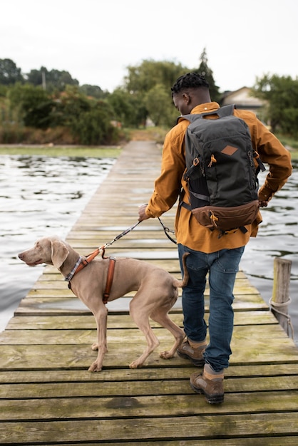 Foto tiro completo homem caminhando com cachorro