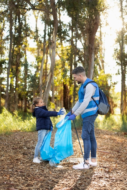 Foto tiro completo, homem e menina, coletando lixo