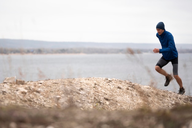 Foto tiro completo joven corriendo en pista