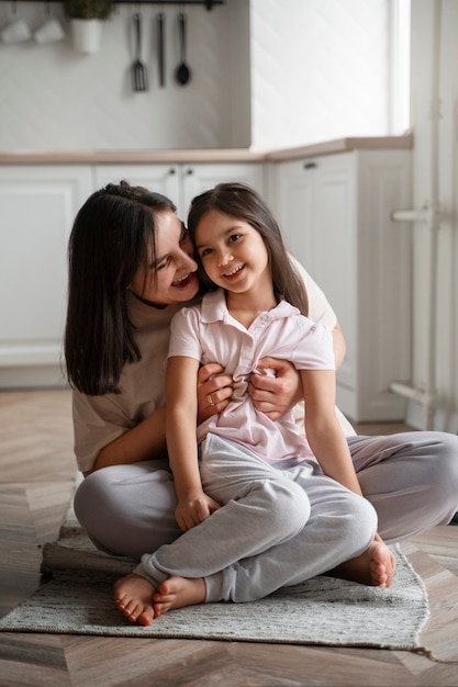 Foto tiro completo madre cosquillas niña