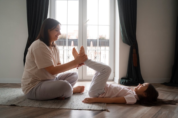 Foto tiro completo madre cosquillas niña