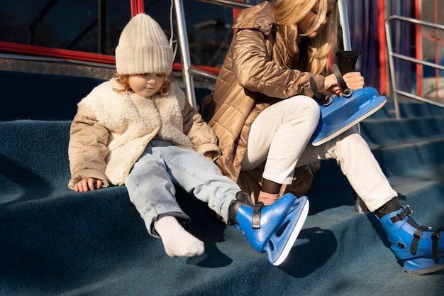 Tiro completo mãe e menina colocando patins
