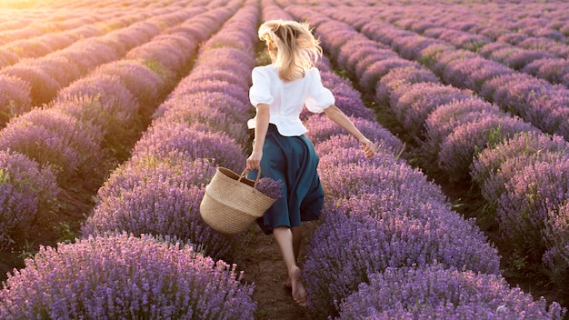 Foto tiro completo de mujer en campo de flores