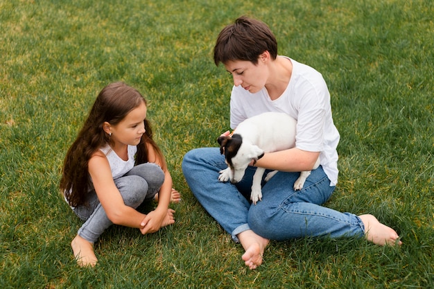 Foto tiro completo mujer y niña con perro