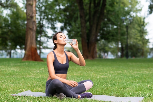 Foto tiro completo mulher bebendo água ao ar livre