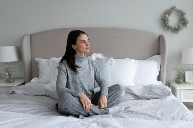 Foto tiro completo mulher sentada na cama