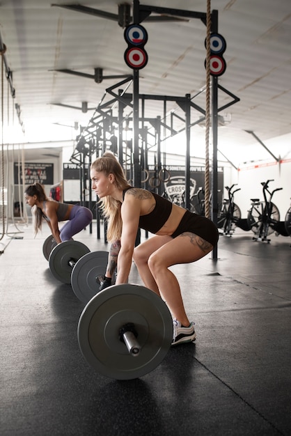 Tiro completo para mulheres treinando com halteres