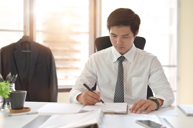 Tiro cosechado del contrato de firma del hombre de negocios que hace un trato en lugar de trabajo de la oficina.